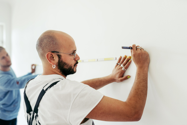 Home-Depot-shopping-man-measuring-wall-with-measuring-tape