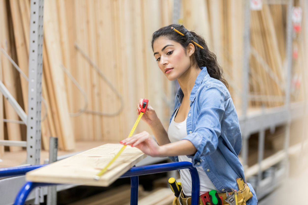 iStock-918377490 Home Depot Shopping Careful hardware store employee measures wooden board