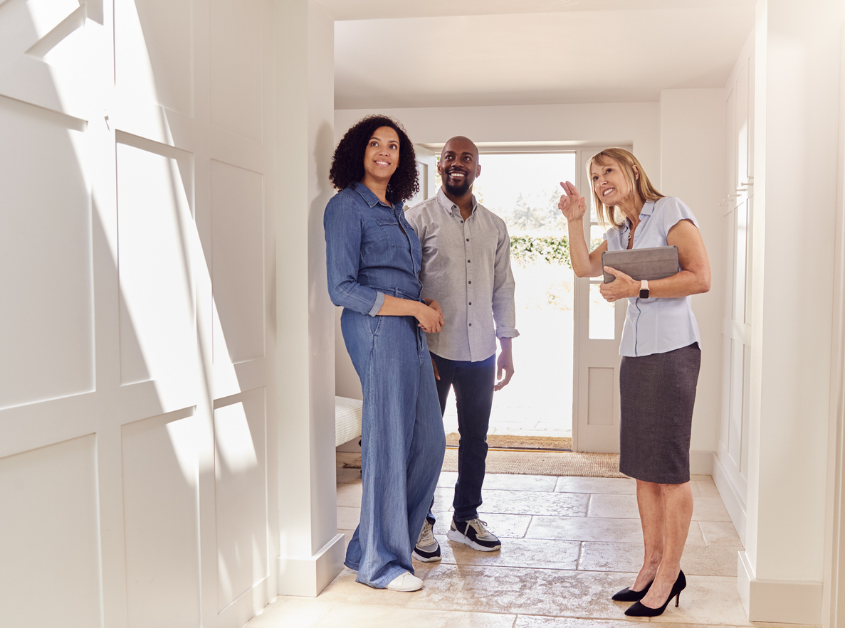 real estate agent pointing out home features to couple