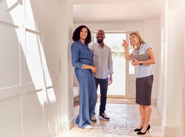 real estate agent pointing out home features to couple