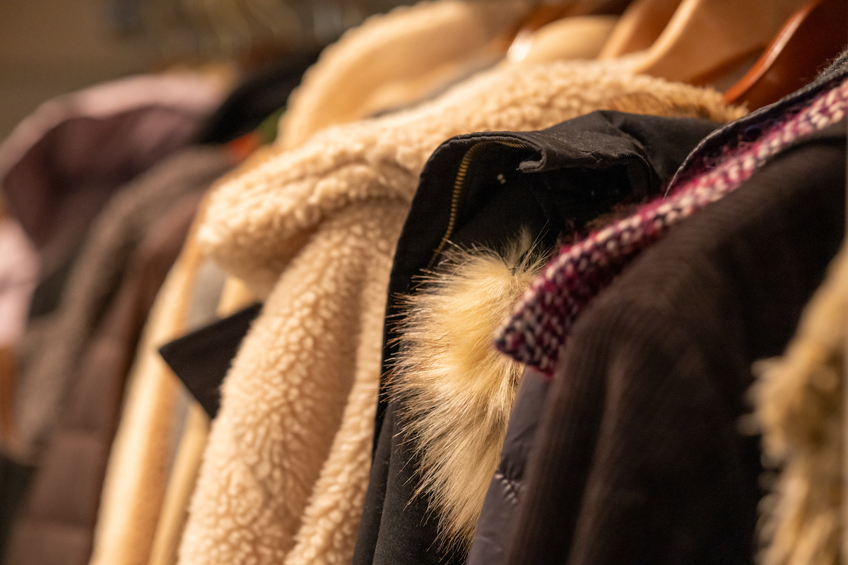 Row of winter coats of different textures in a coat closet.