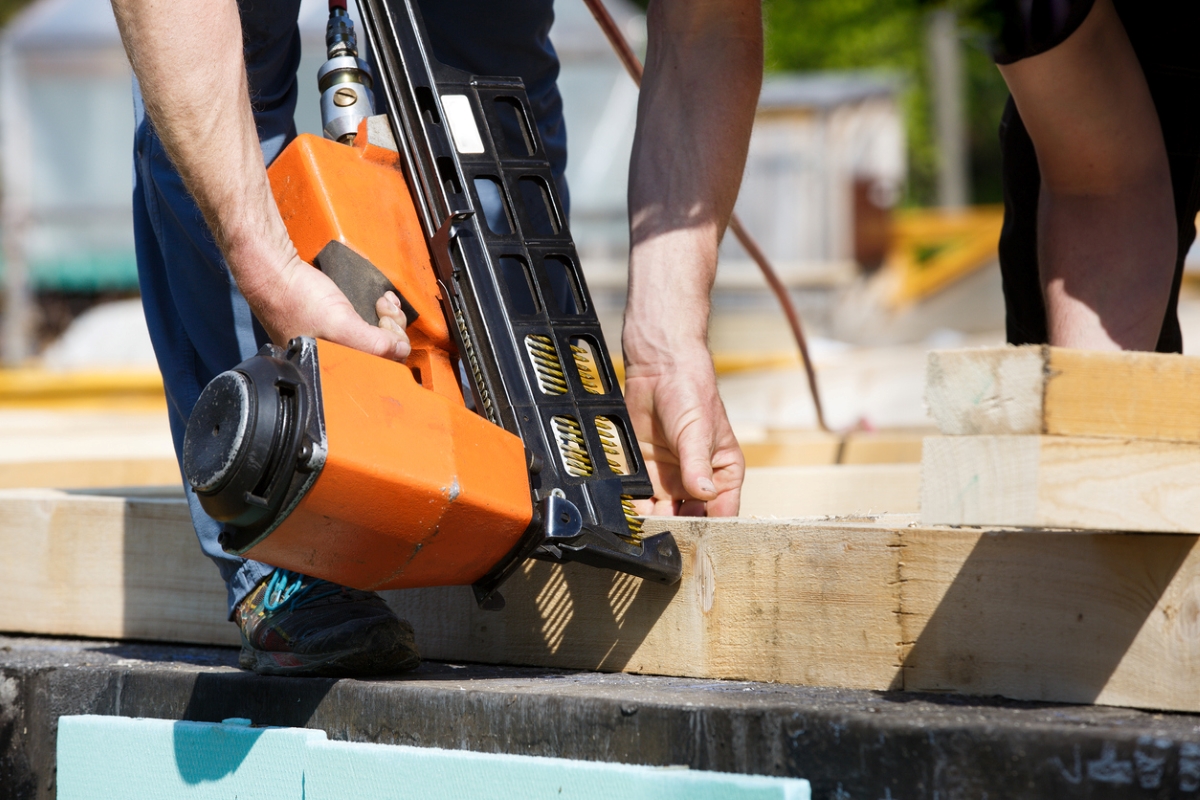 most dangerous power tools - man using orange nail gun