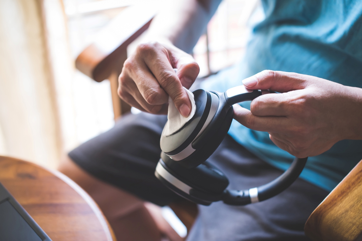 electronics you never clean - man cleaning black headphones