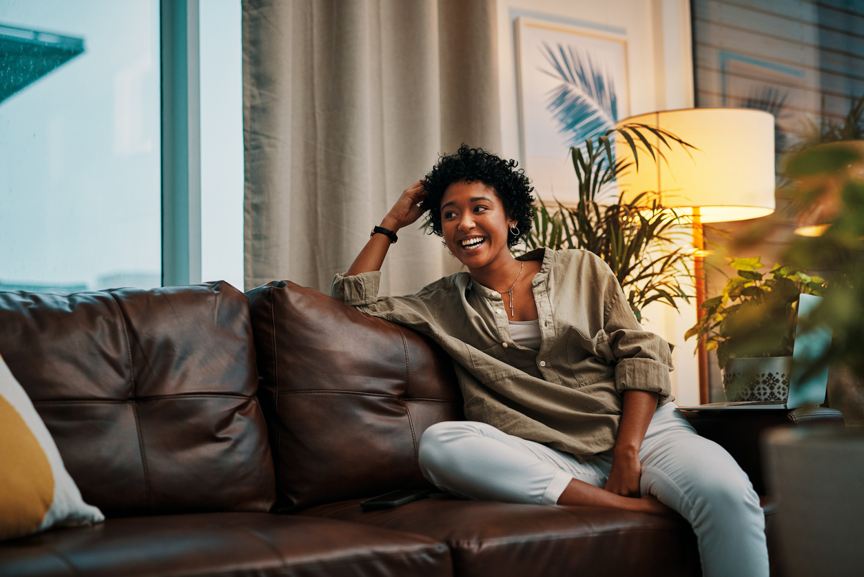 iStock-1273305872 smart places to hide shelves woman sitting on leather couch