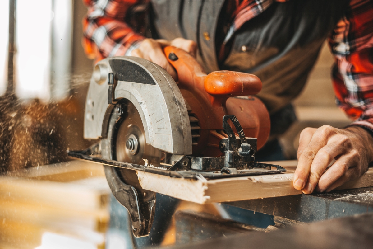 most dangerous power tools - man using circular saw close to hand