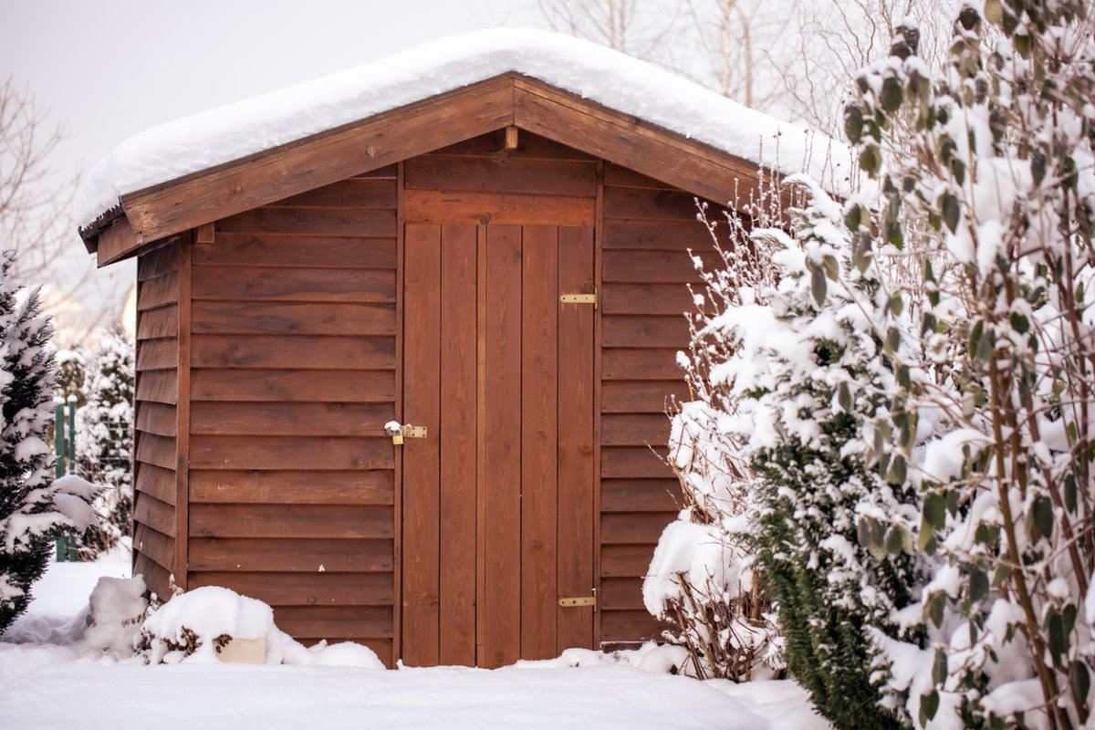 Wooden insulated shed topped with a snow-topped roof