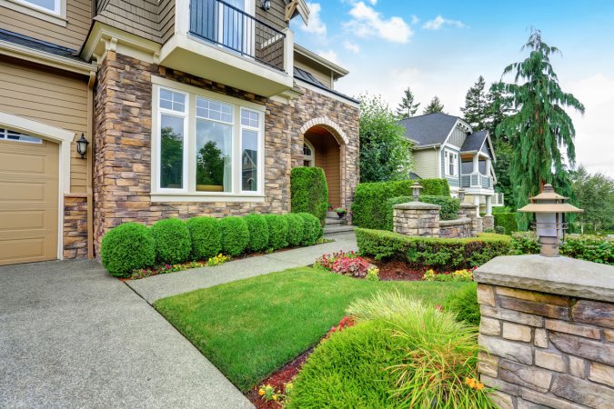 exterior front of large house with stone front and landscaping