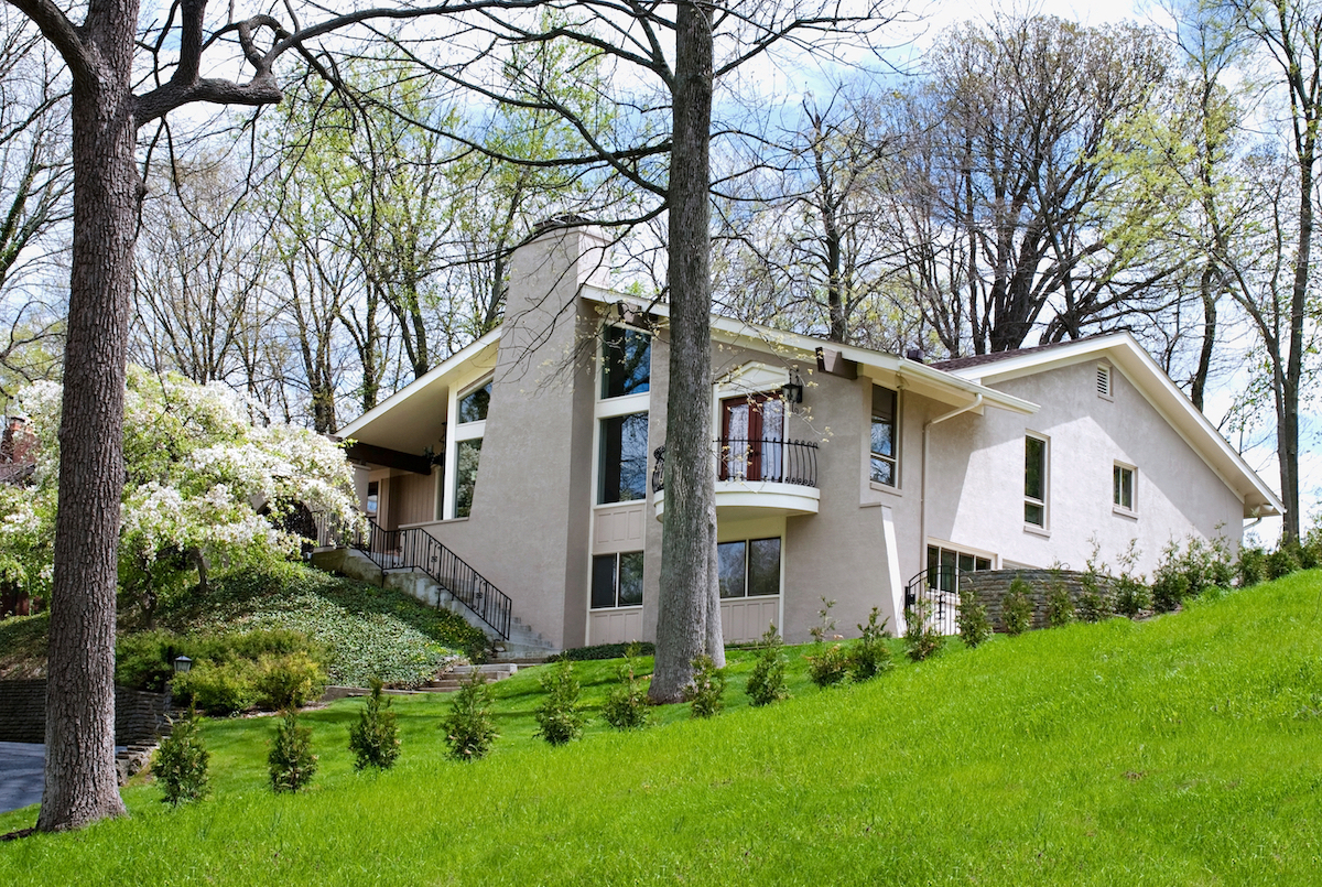 white stuccoed house with a sloping lawn