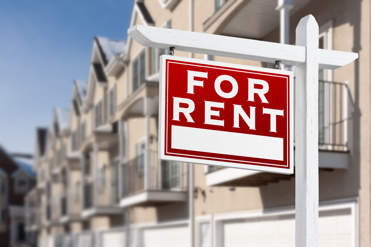 iStock-1362129126 master planned communities For Rent Real Estate Sign In Front of a Row of Apartment Condominiums Balconies and Garage Doors