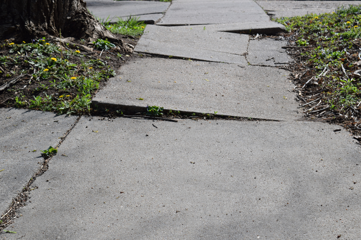 severely cracked concrete sidewalk and driveway