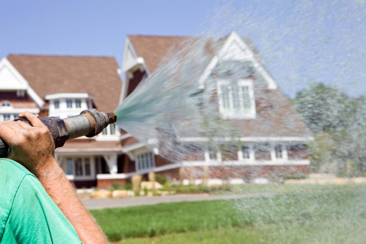 A close up of a person hydroseeding.