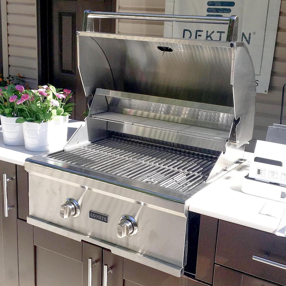 A built-in grill outside next to some plant pots