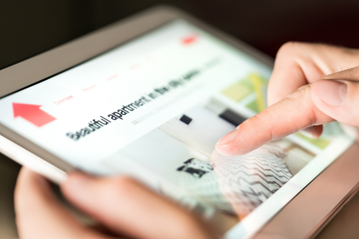 Man searching for property for rent online with tablet.