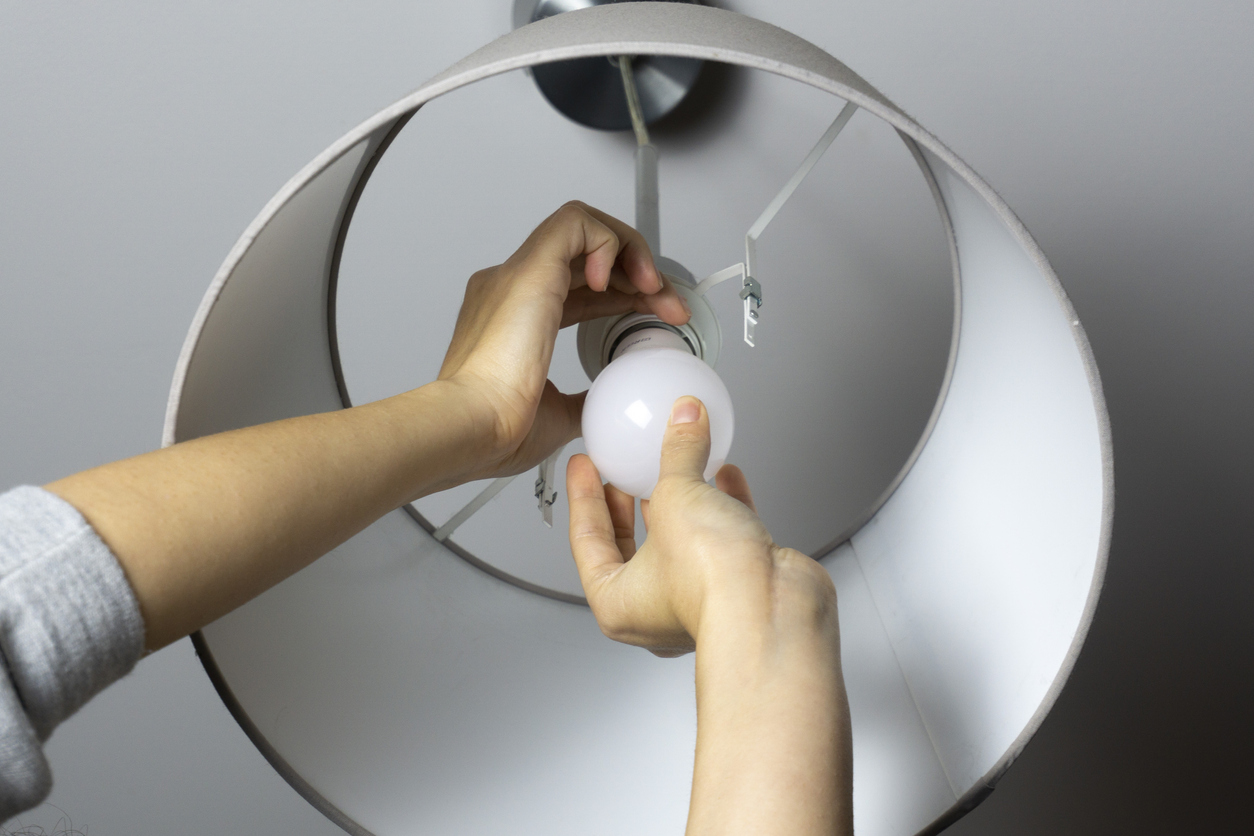 woman changing a light bulb