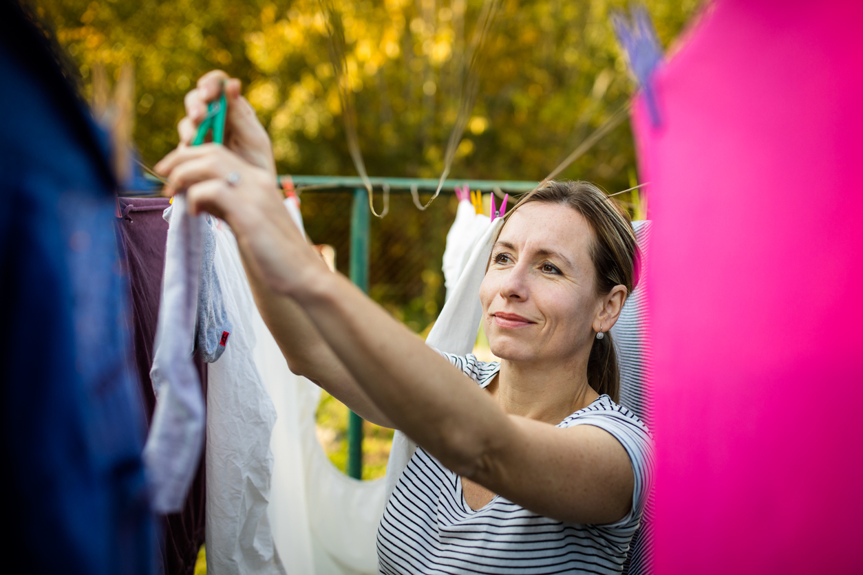 woman hanging clothes on clothes line outside