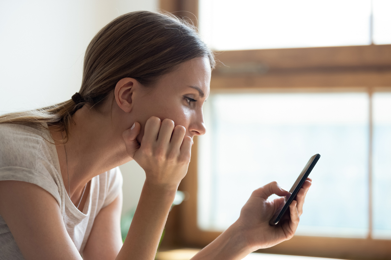 Young woman reading news on her smartphone.