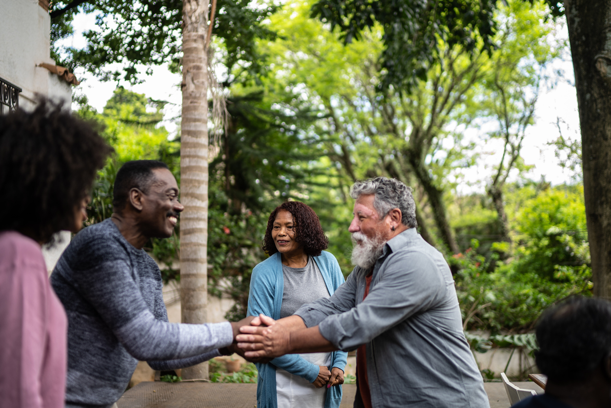 two middle aged couples meeting each other as neighbors outside home