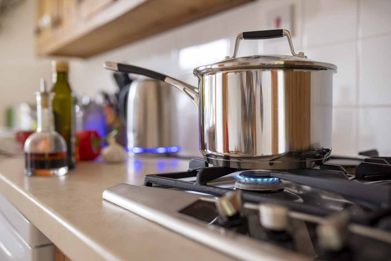 gas stove turned on with pot on it