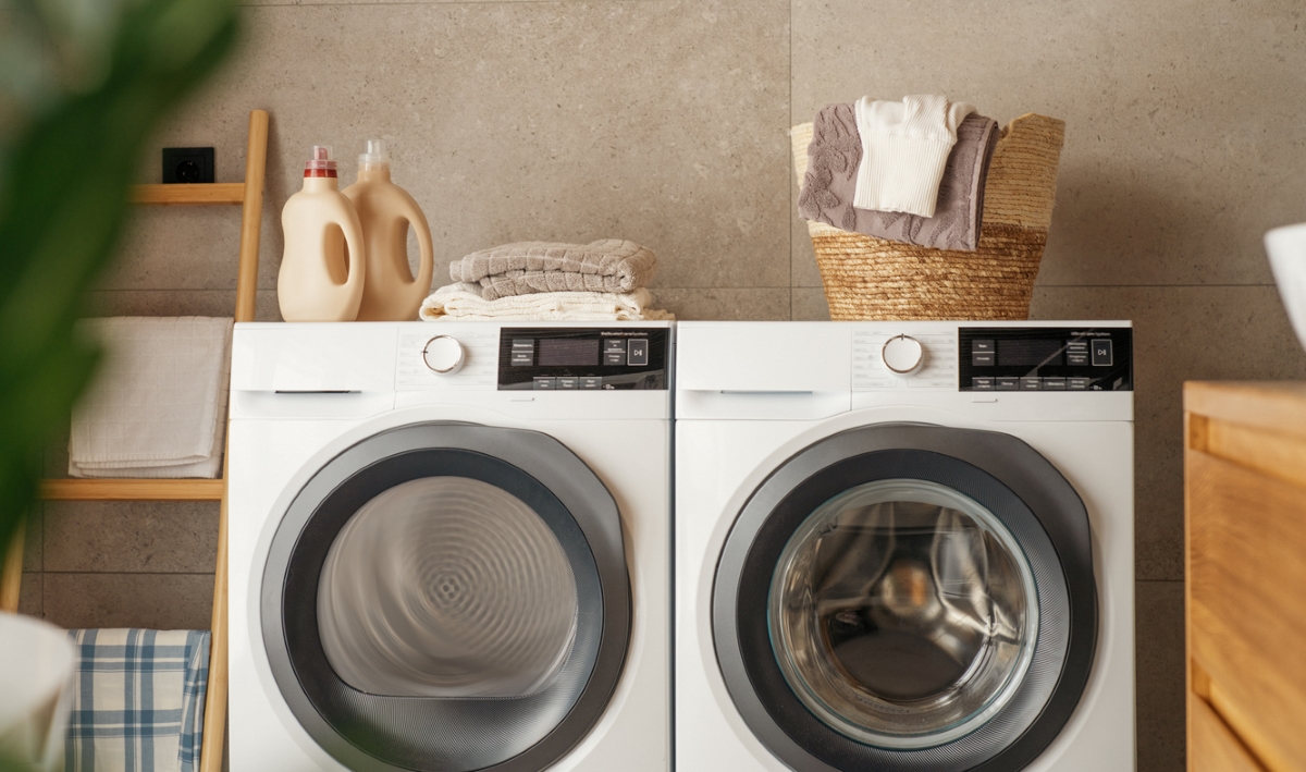 White front-load washer and dryer in a modern, organic-style laundry room.