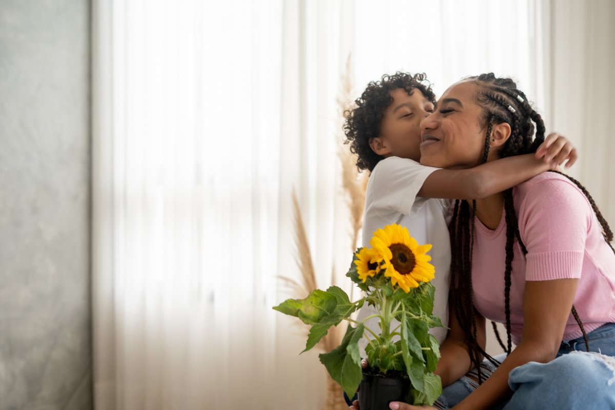 Son handing flower to his mother on mother's day