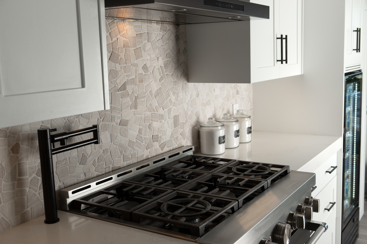 Modern kitchen with a light-gray flagstone backsplash and stainless steel gas stove