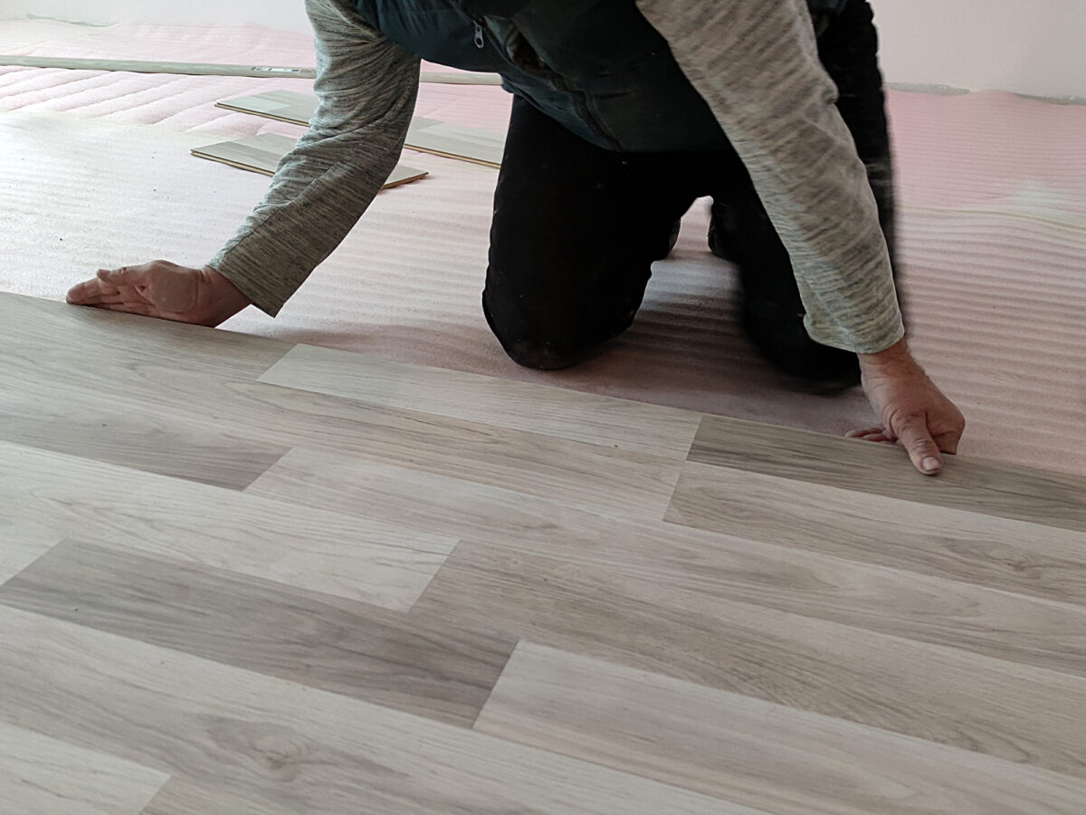 Laminate planks with an ash wood finish being installed