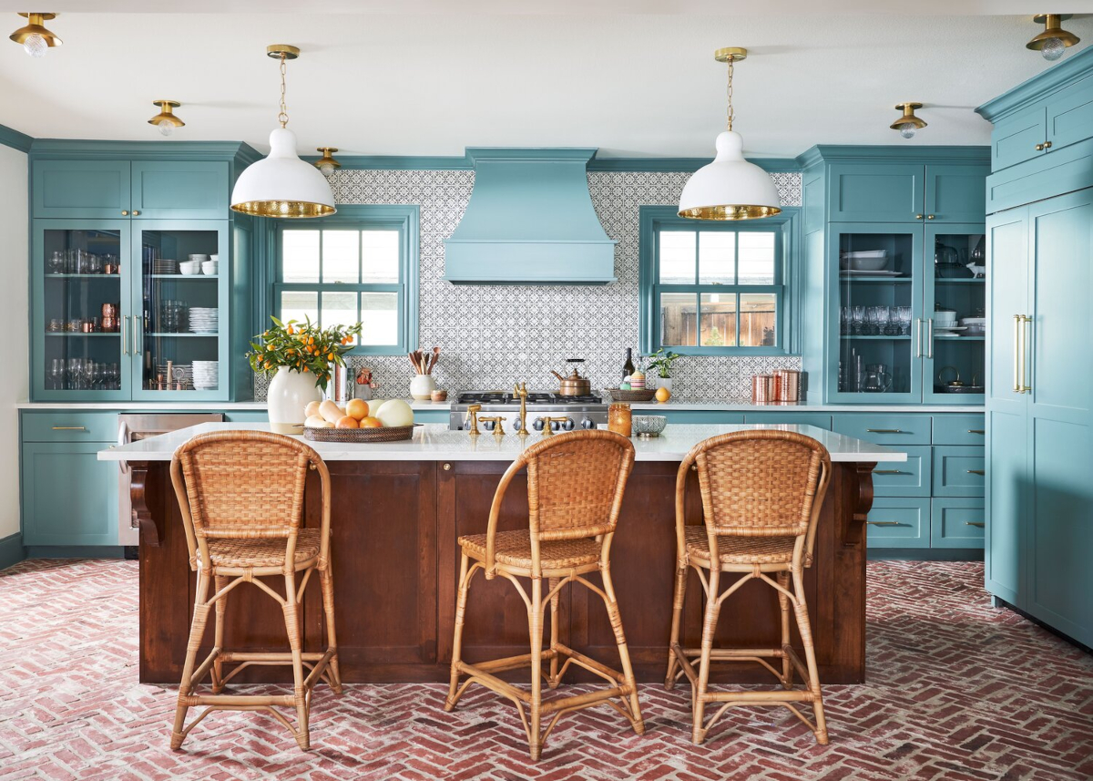 Boho-style kitchen with rattan barstools, marble kitchen island, and a gray-and-white tile kitchen backsplash