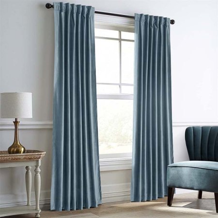  A blue pair of Dreaming Casa Darkening Thermal Velvet Curtains installed in a formal living room.