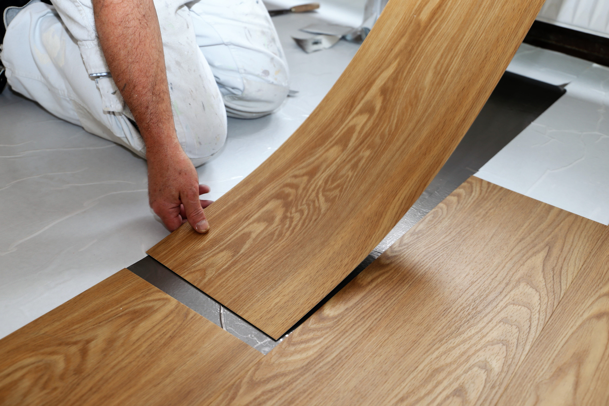 Vinyl tile flooring with a wood finish being laid