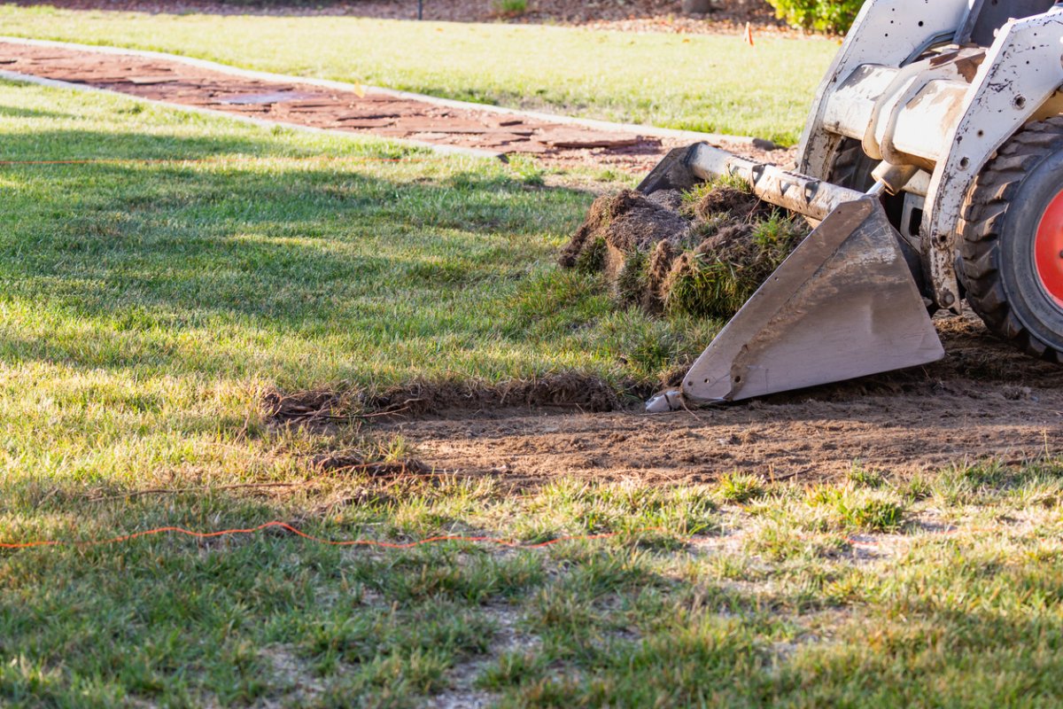 Small Bulldozer Removing Grass From Yard