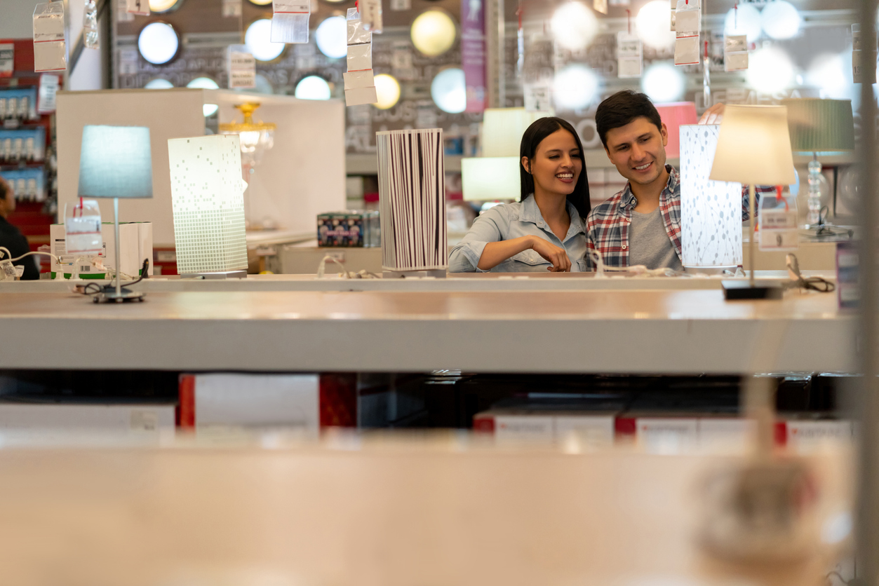 Happy couple buying a lamp at a home improvement store