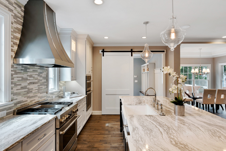 white-and-beige-kitchen-with-wood-floors-and-a-white-sliding-barn-door