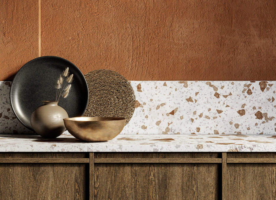 Orange kitchen interior with terrazzo countertop and gold and clay decor