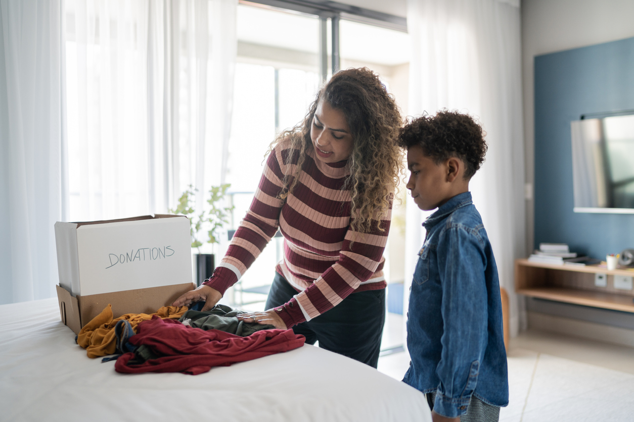 Mother and son sorting clothes for donation at home