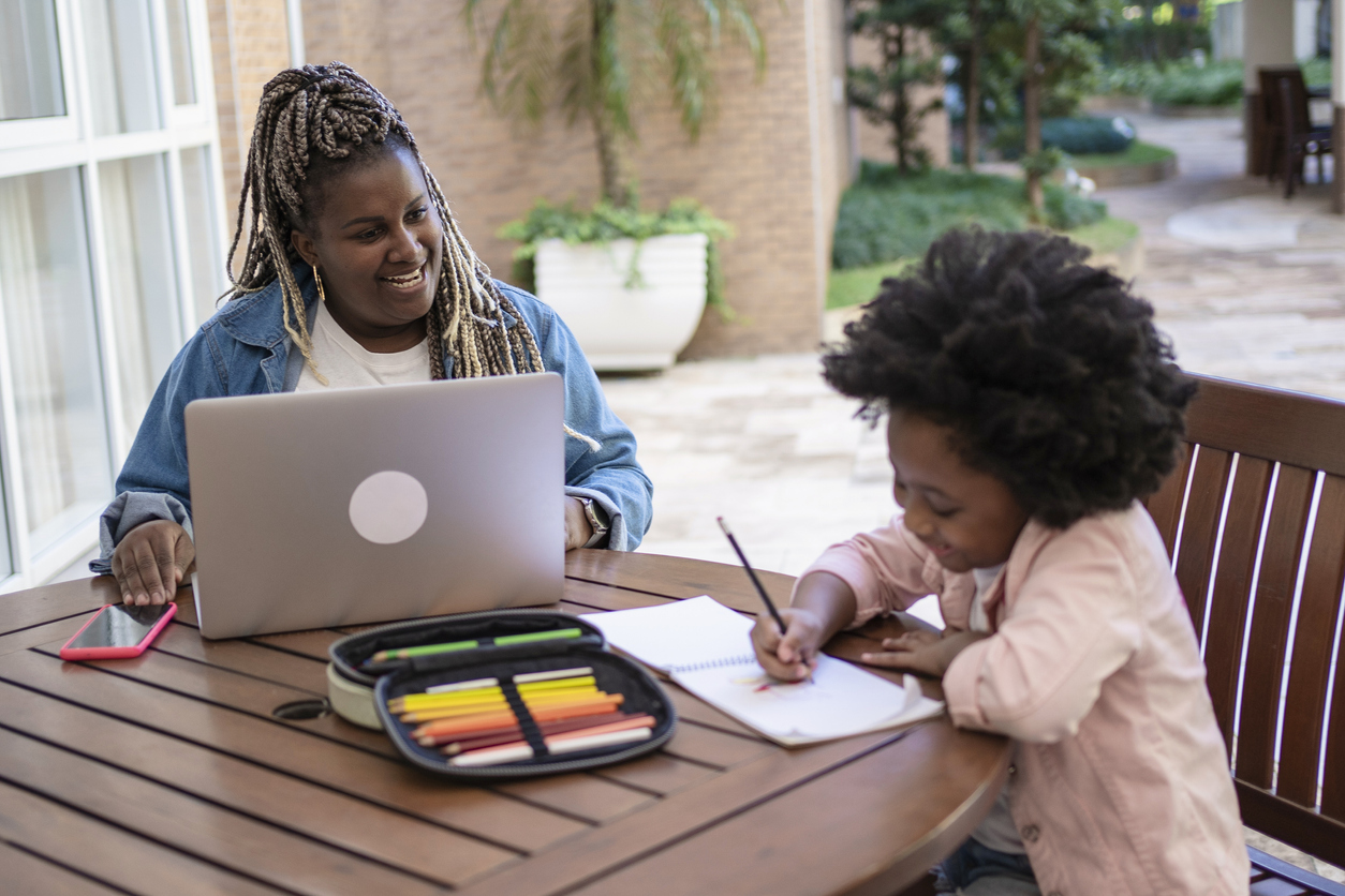 Woman working while her niece draws