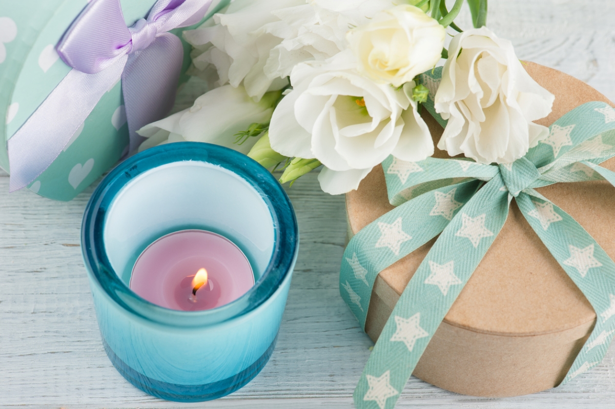 Lit candle next to packaged gifts