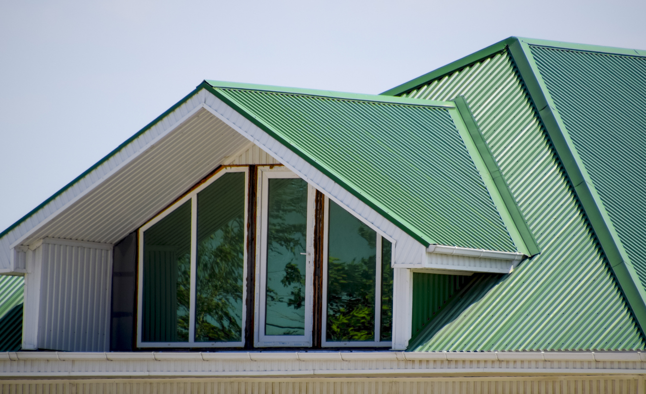 view of top floor of large house with green metal roof with windows into attic space