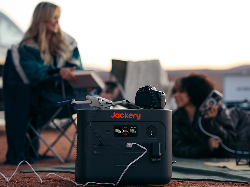 Two women charging a drone and camera