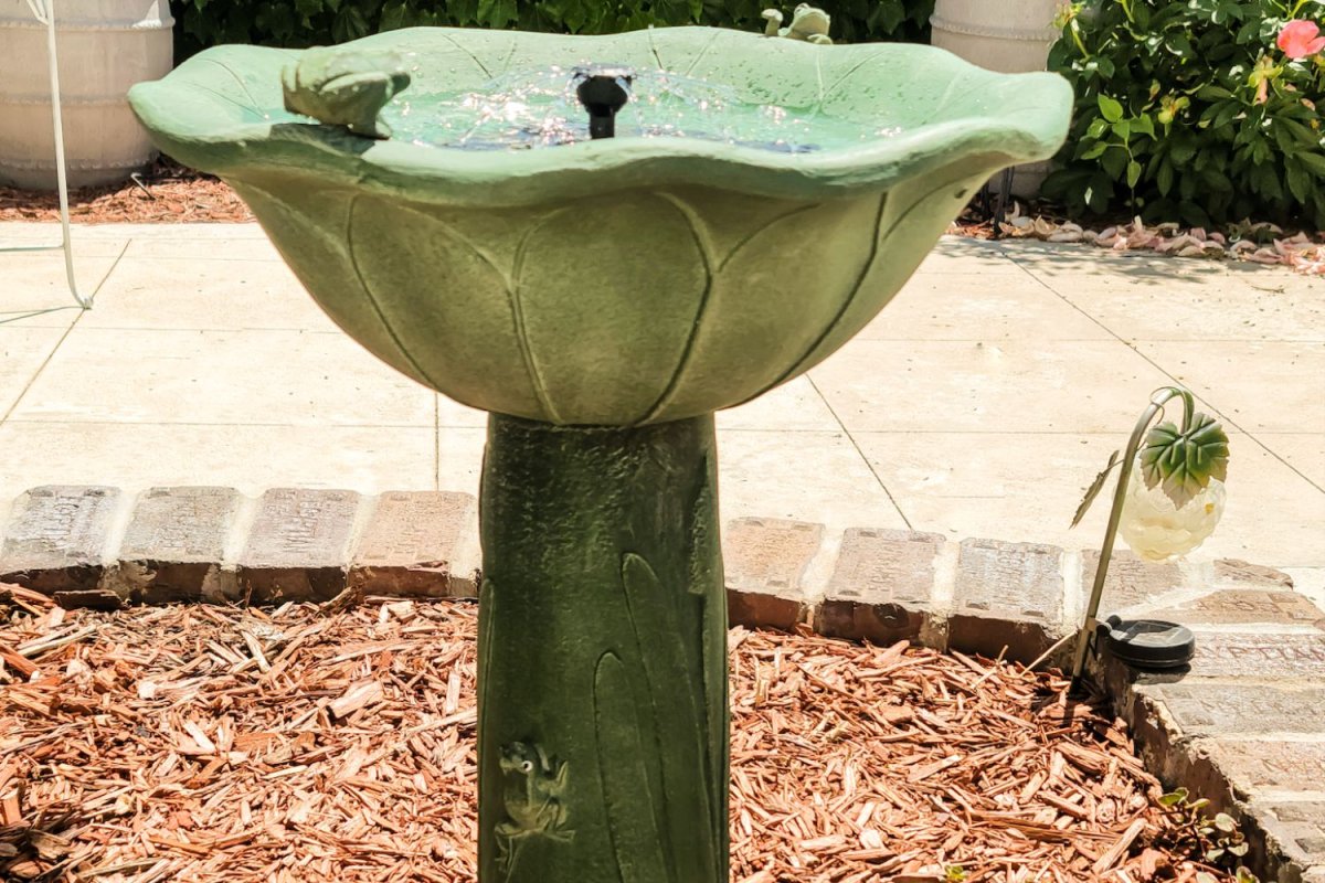 Smart Solar bird bath fountain in cedar mulch plant bed