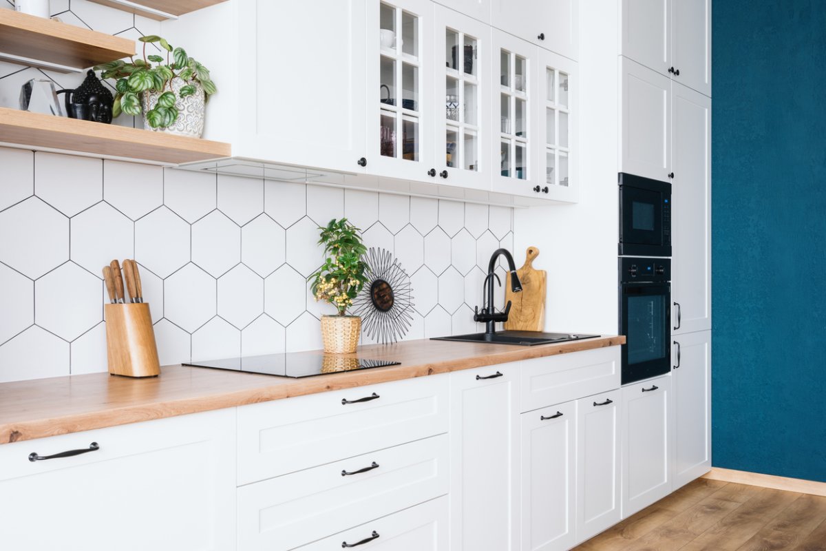 Angle view of modern white kitchen cabinets and drawers