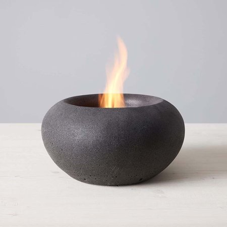  The TerraFlame Stone Tabletop Fire Bowl with a small flame coming from it.