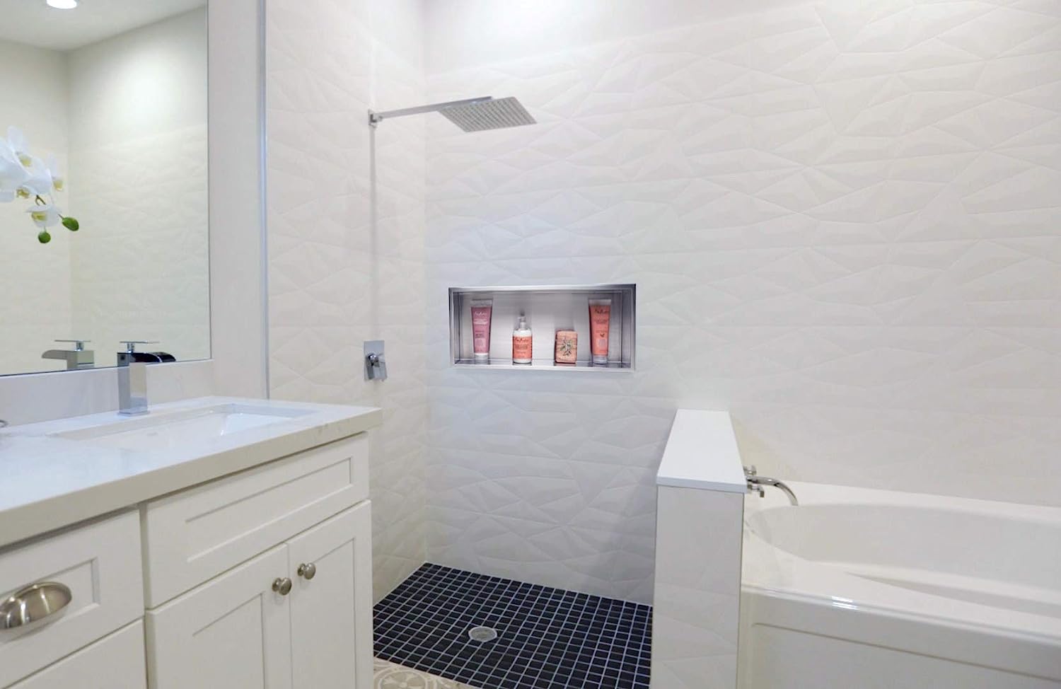 white bathroom with white tube and sink with stainless steel shower niche in middle of wall