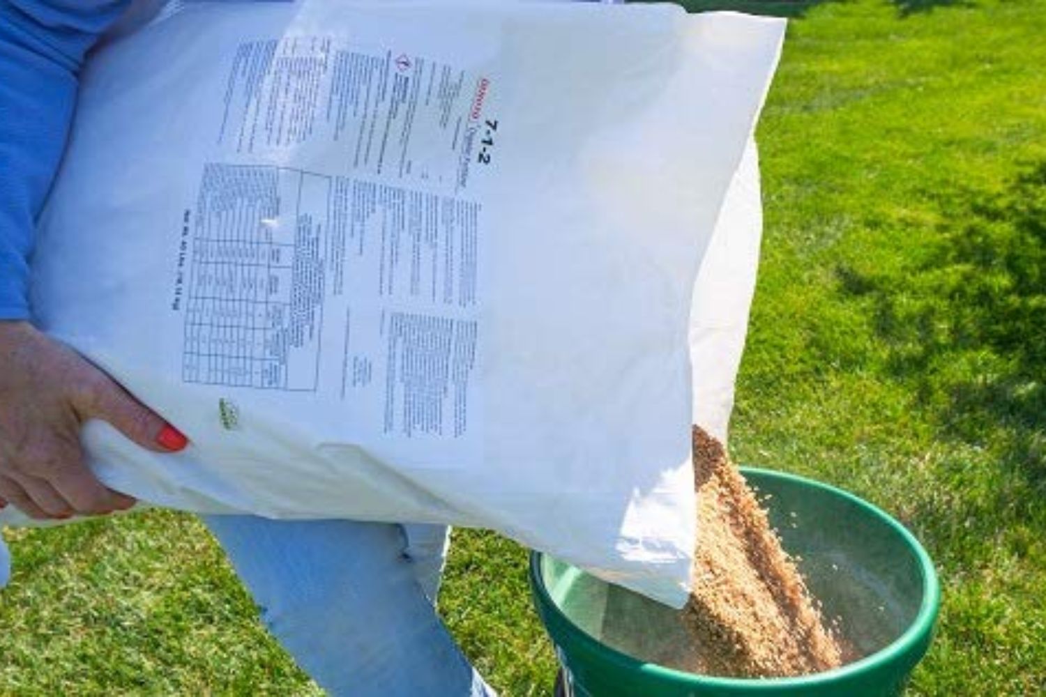 Someone pouring the best lawn fertilizer for spring option into a bucket