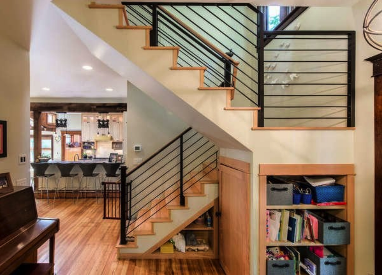 large open plan living space with staircase and landing with storage shelves and cabinets underneath