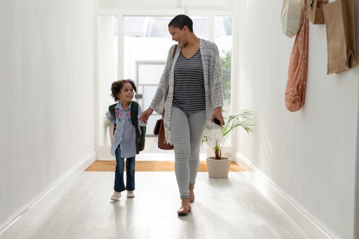 Mother and daughter walking into home