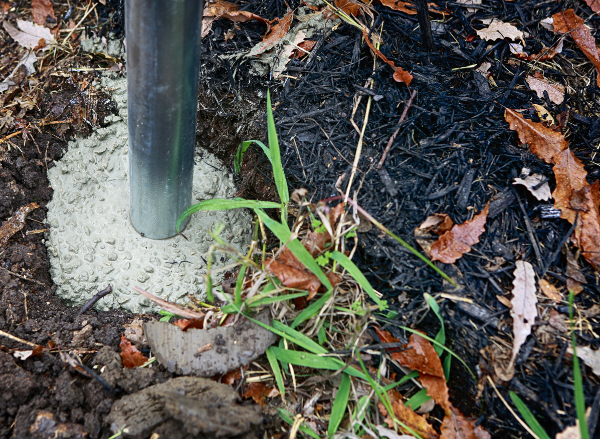 metal chain link fence post set in concrete for fence installation