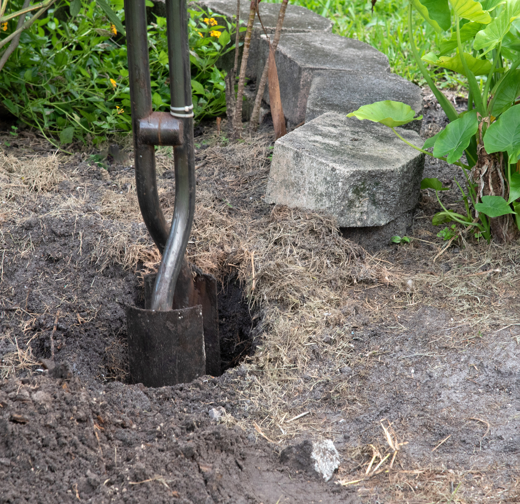 post hole digger removing soil for setting chain link fence post