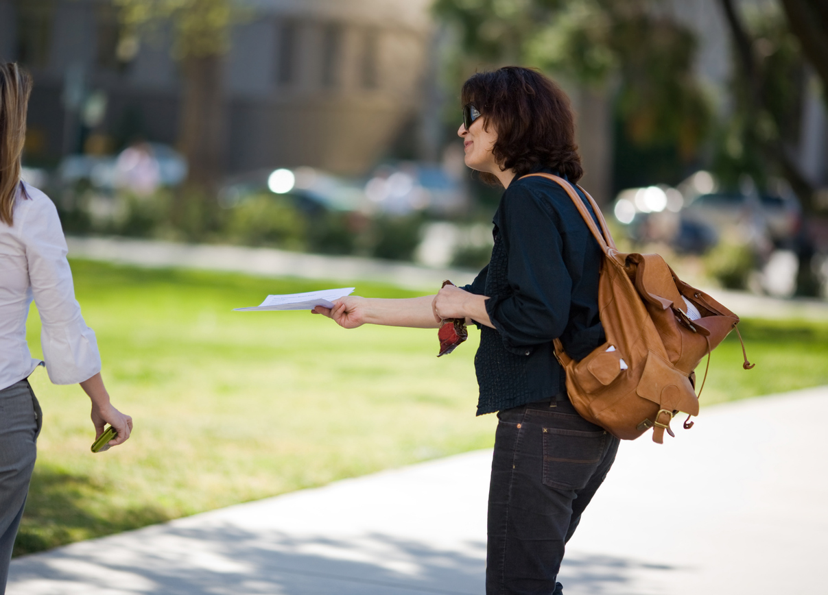 woman handing out flyers