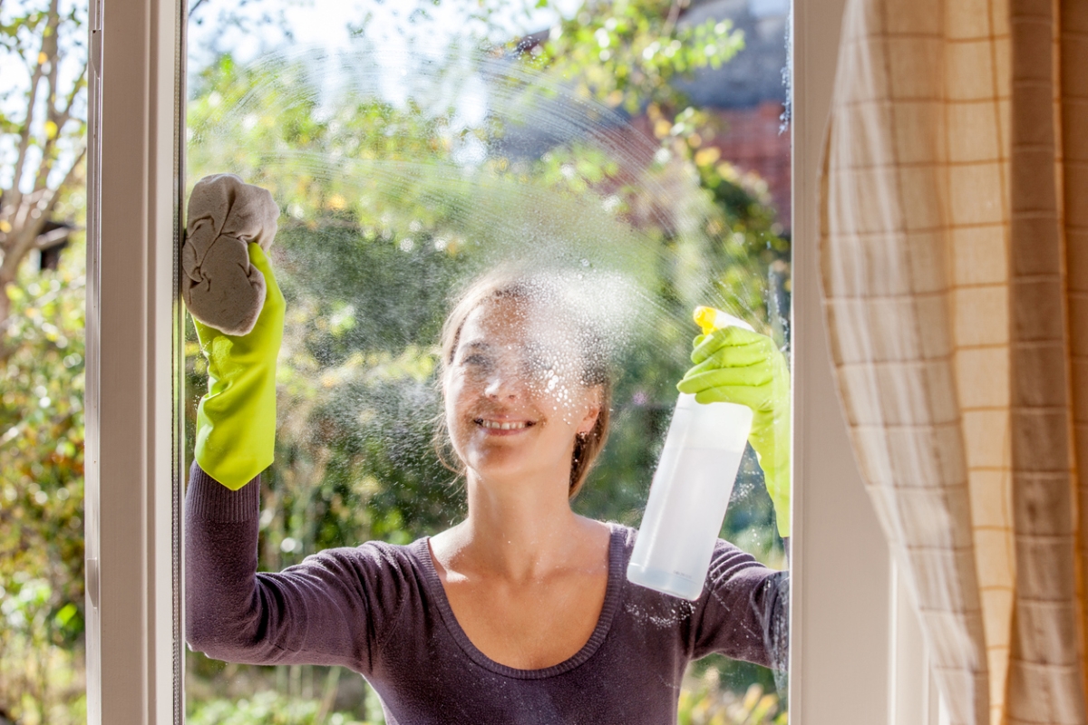 Woman cleaning window from outside