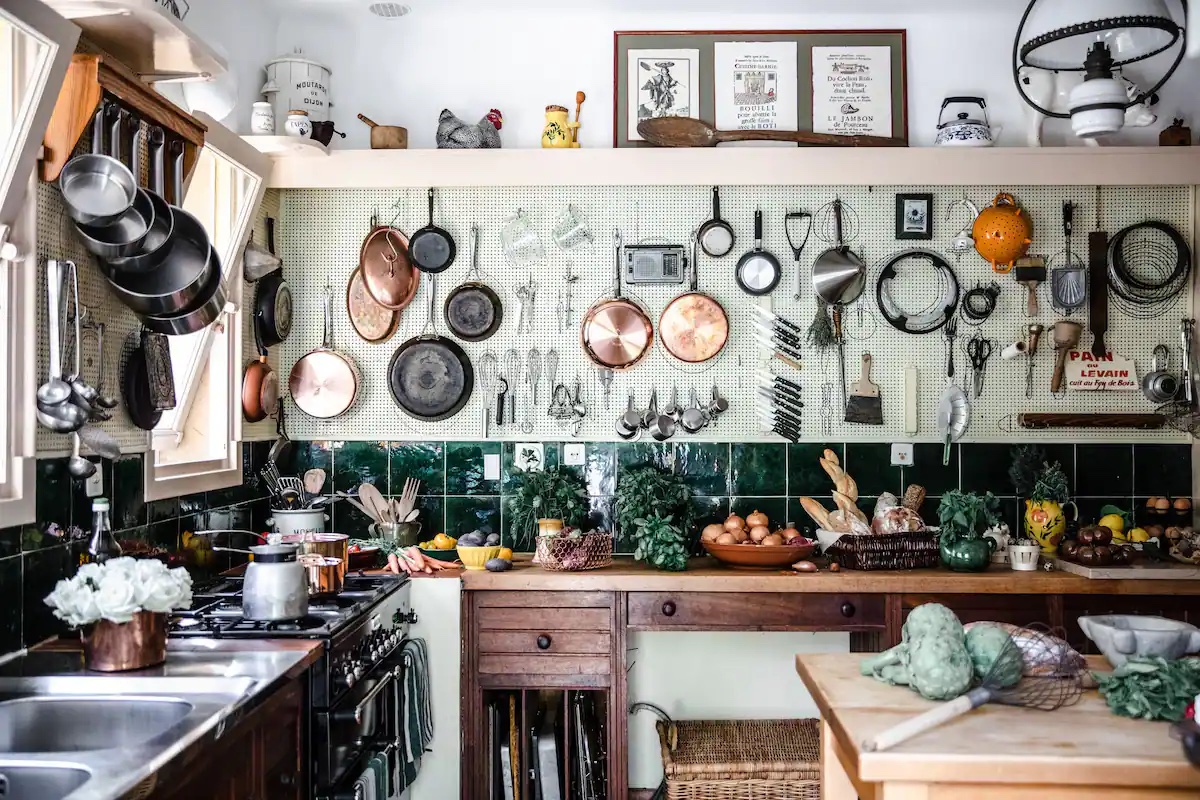 Pegboard covering kitchen wall and holding pots, pans, and utensils